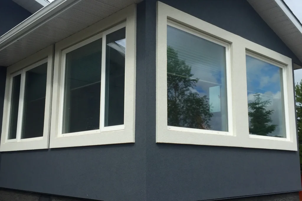 Smooth dark parging on a foundation below large windows