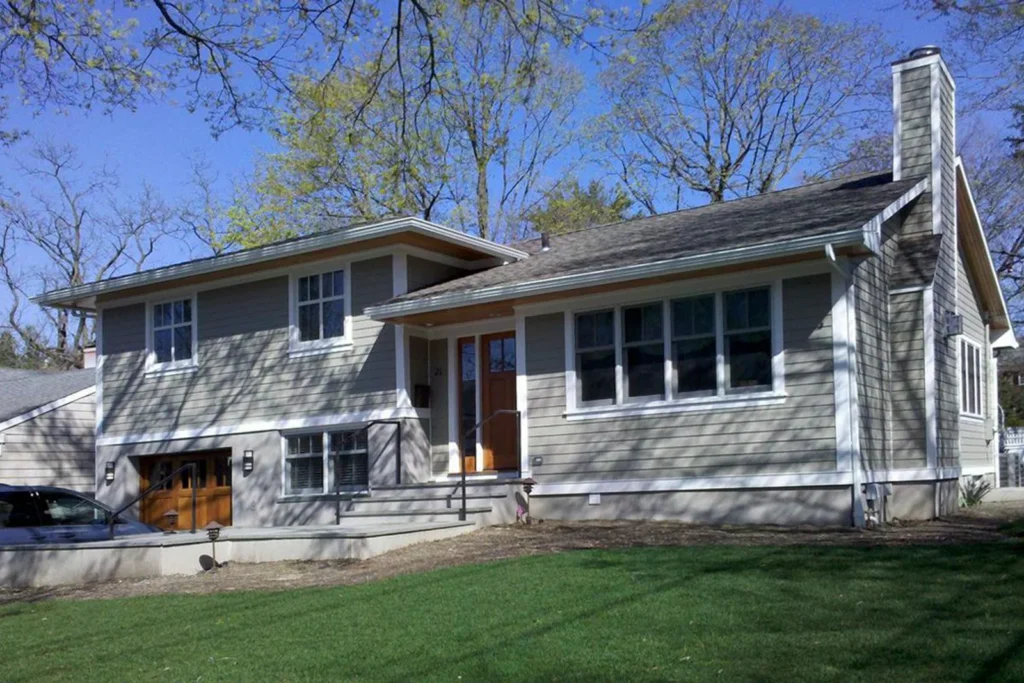 Split-level house with grey siding and a large front lawn