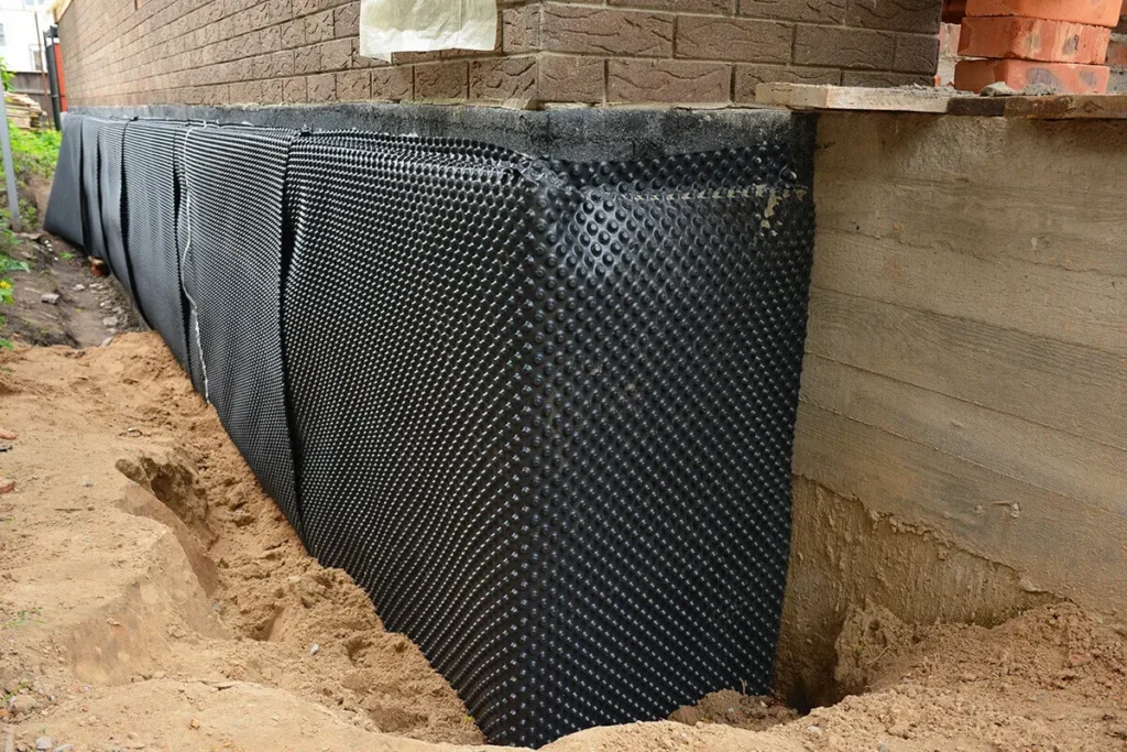 Dimpled drainage membrane on a foundation wall in a deep excavation