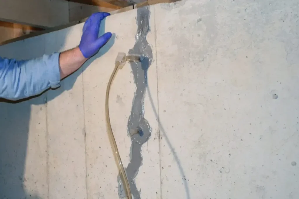 Injection port and tubing set into a sealed crack on a basement wall