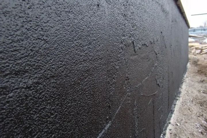 Dark textured protective coat on a foundation wall